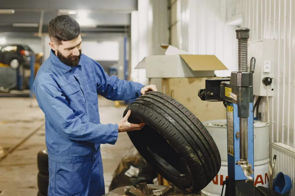 Technician rolling a tire in the shop