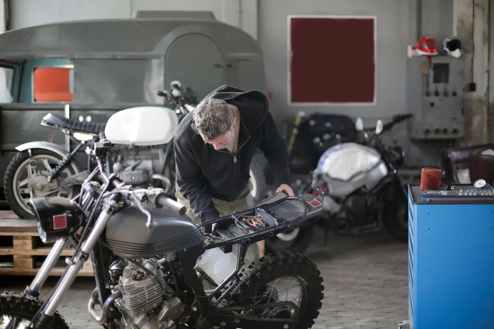 Mechanic working on a motorcycle in a garage