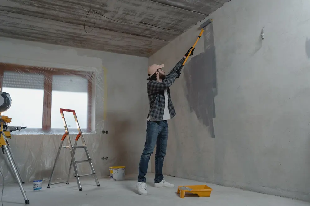 Painter rolling an interior wall