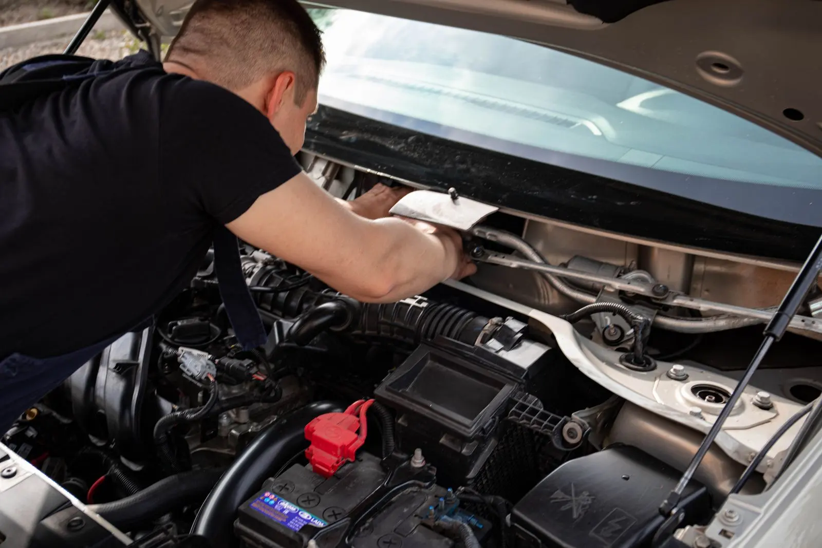 Mechanic working under the hood of a car