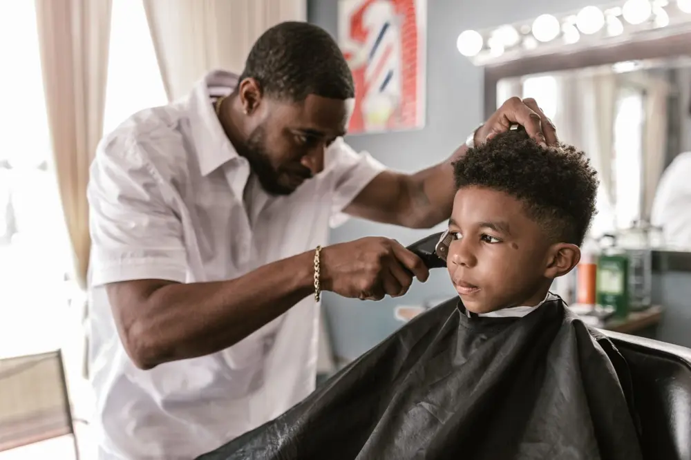 Barber trimming a boy's hair