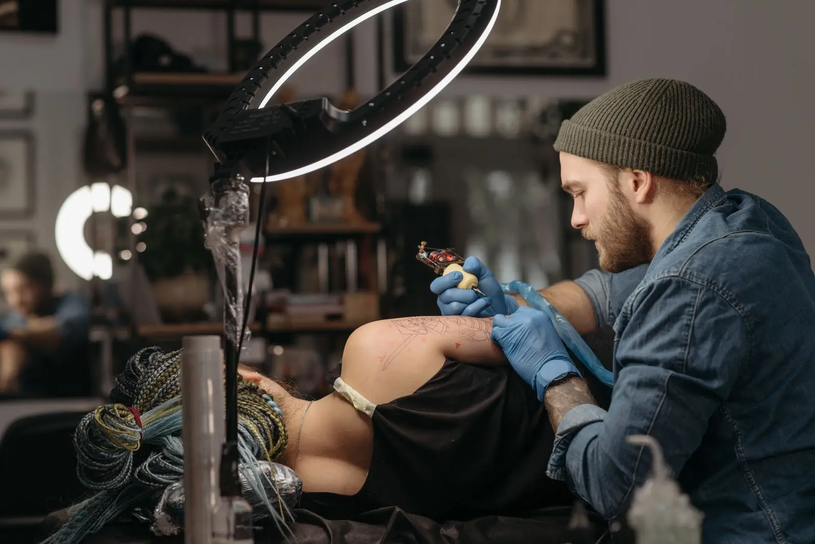 Tattoo artist tattooing a client's arm